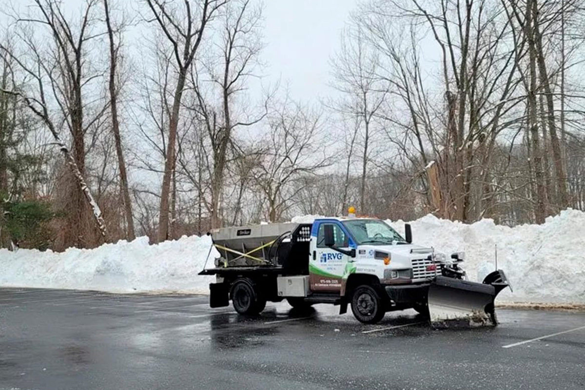 a truck with a plow on the side of the road