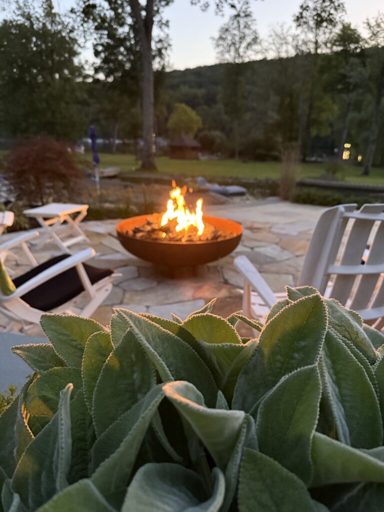 Outdoor fireplace with a seating area on a natural stone patio