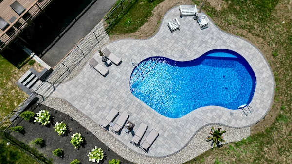 Bergen County backyard with modern gray paver patio and outdoor kitchen by RVG Landscape Design & Build